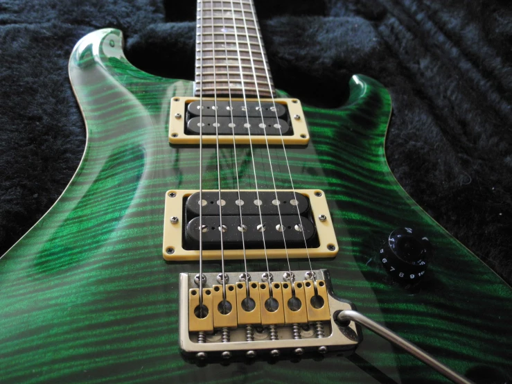 a green and black guitar head sits on a cloth