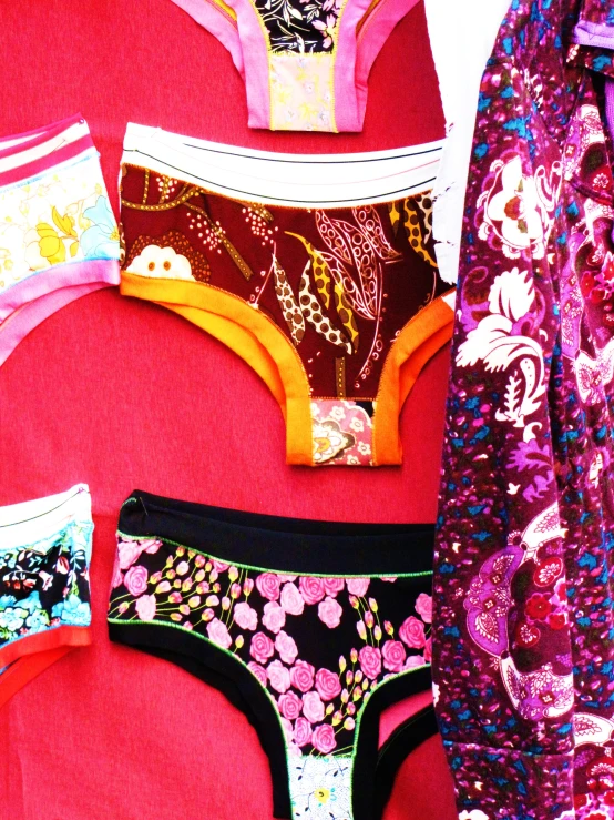 several underwear are shown laying on a red surface