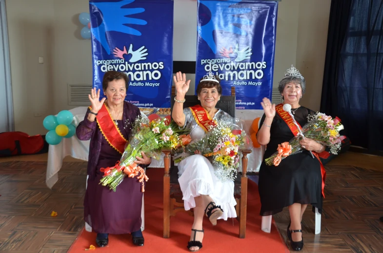 a group of three women standing in front of two banners