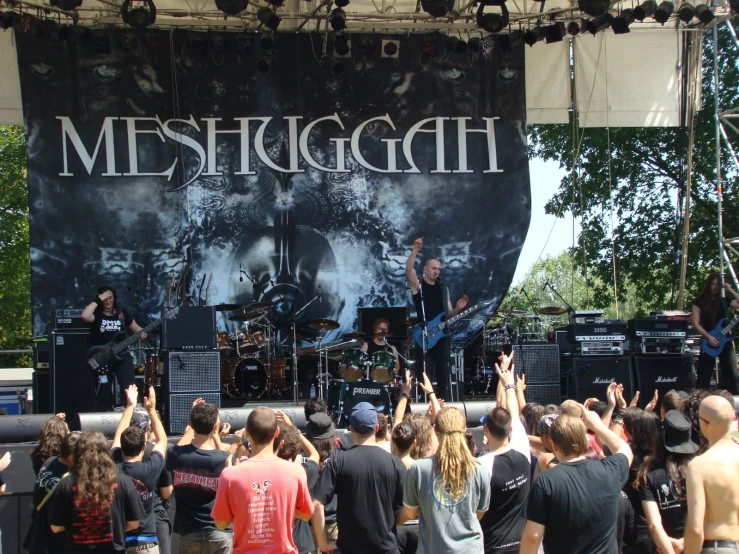 group of people with arms up at concert stage