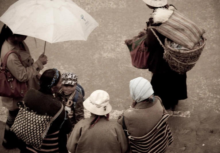 four people in hats, some with umbrellas