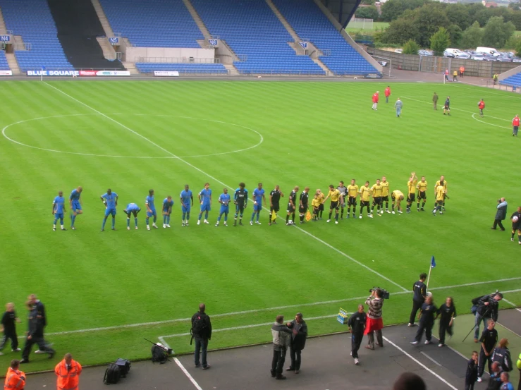 a soccer team gather on the field for a minute's practice