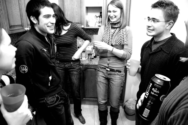 a black and white po of three people laughing in the kitchen