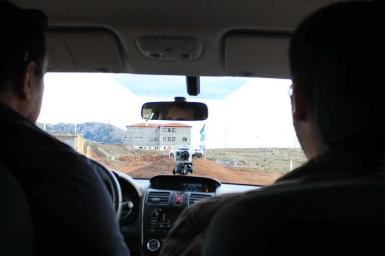 the view from inside the car looking out to dirt roads