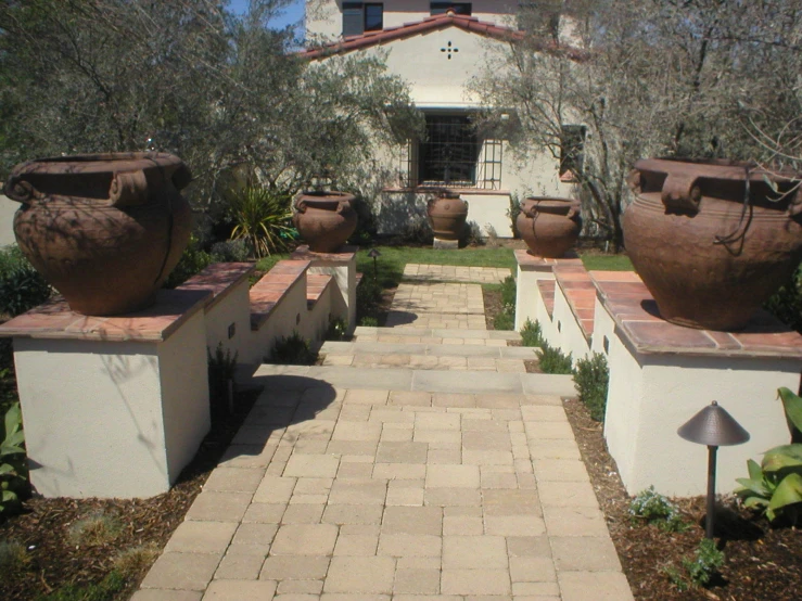 the outside of a house has four big vases in it