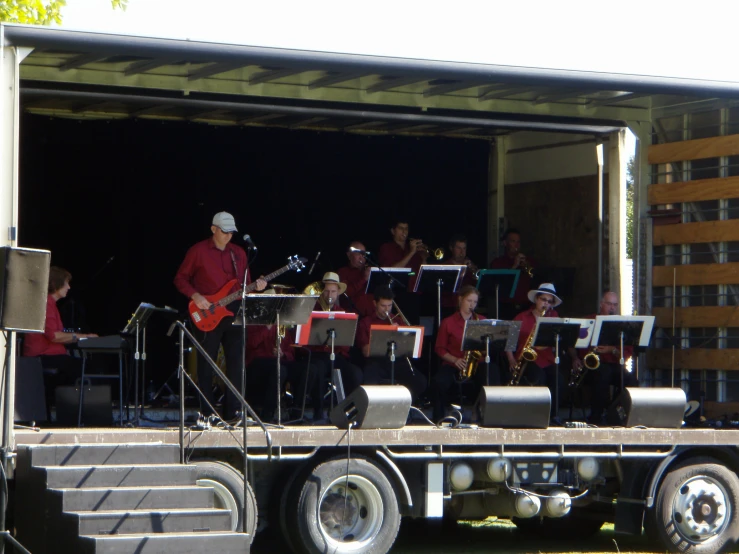 a band playing on a bus with a group on the side