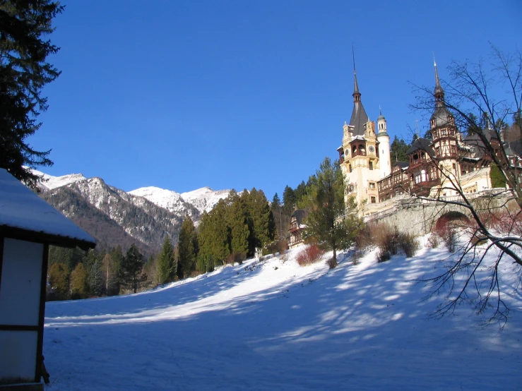 a castle sits on the top of a snowy hill