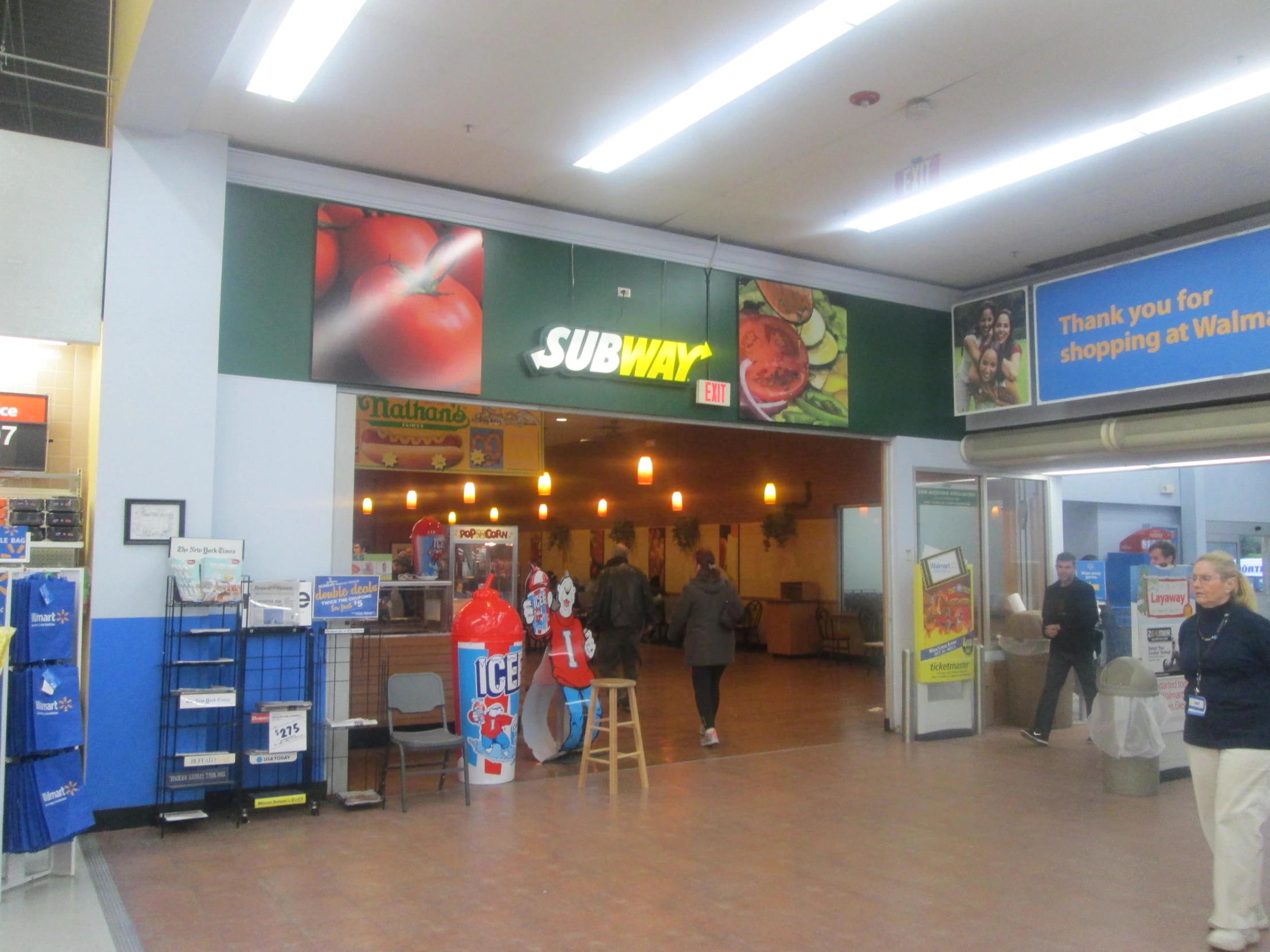 the entrance to a grocery store with people walking around