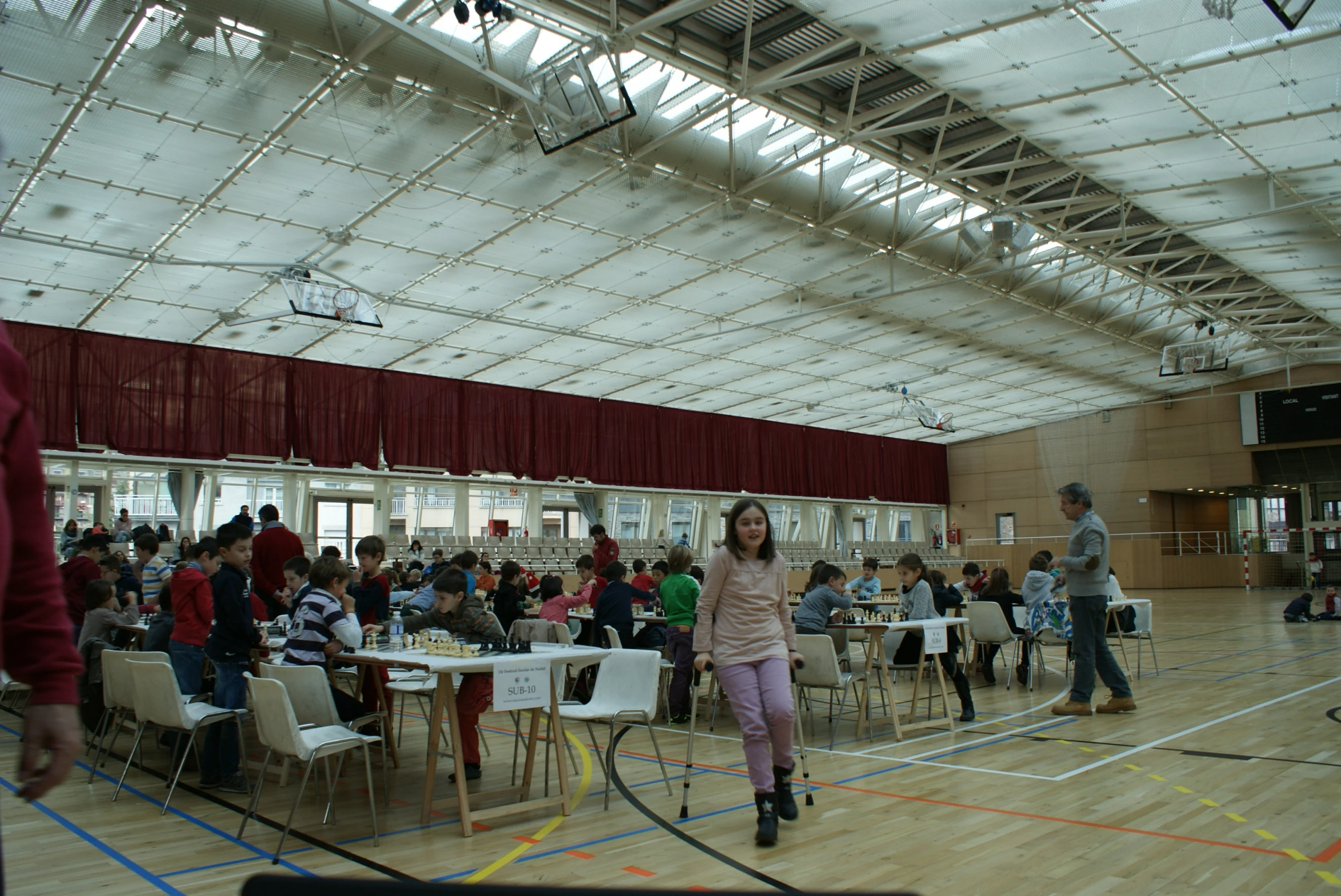 a woman in a white sweater is walking in an auditorium