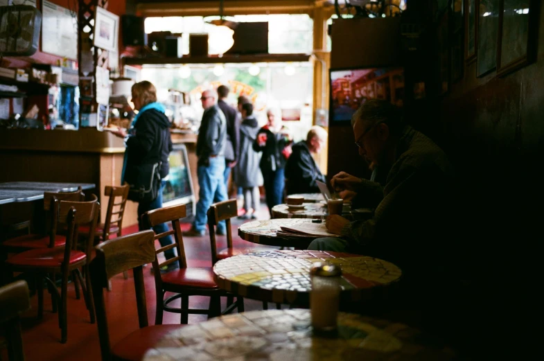 people are standing in a restaurant with red chairs