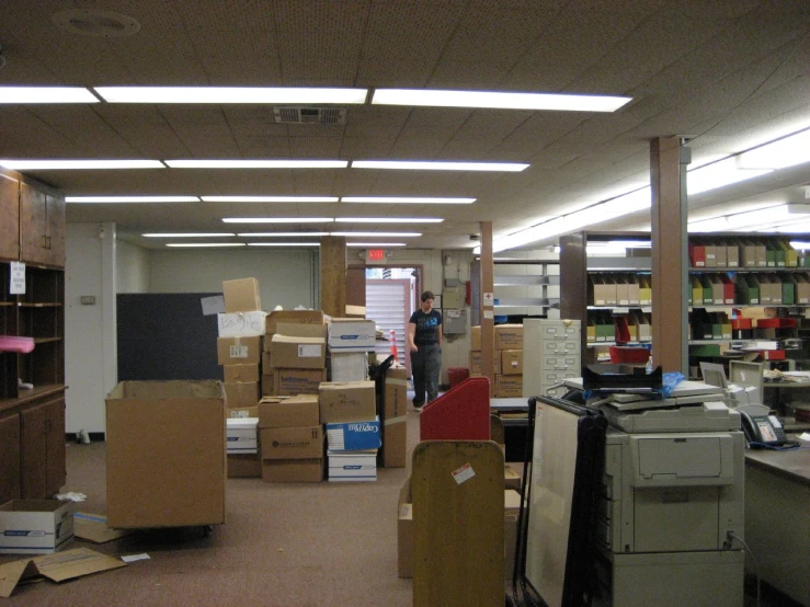 some people are at a large open room with many boxes on the shelves