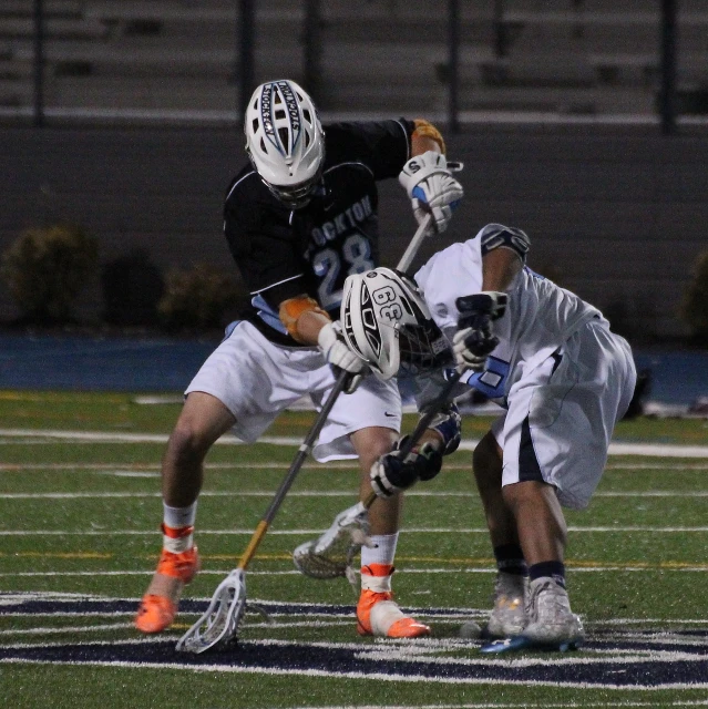 two lacrosse players playing in a game