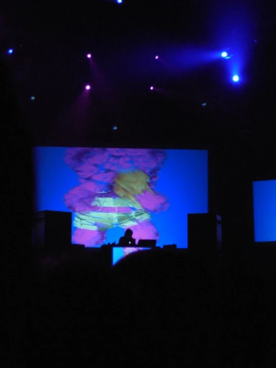 a man is sitting in front of his laptop at a concert