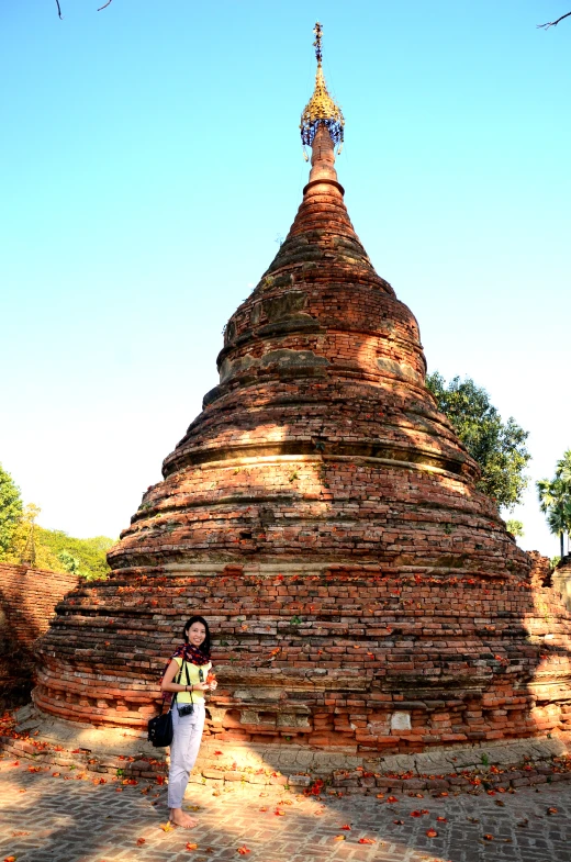 a girl standing in front of a large brick structure