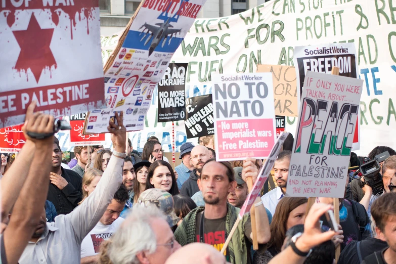 a crowd of people holding signs on top of each other