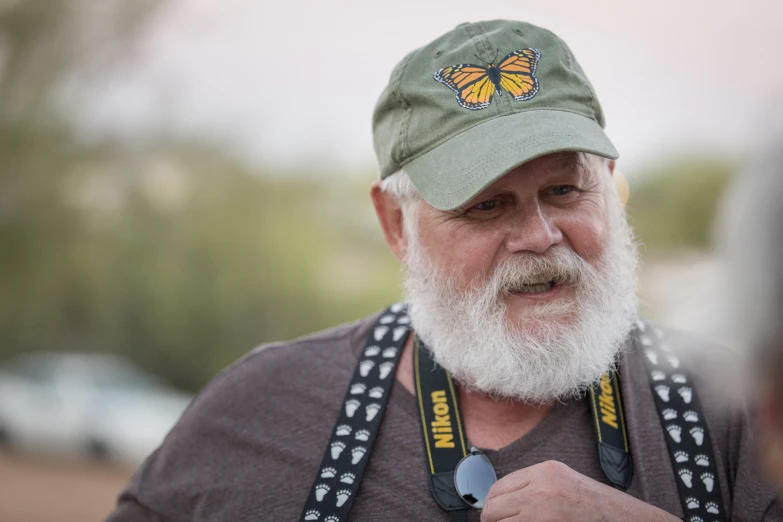 a man with a gray beard wearing a green hat