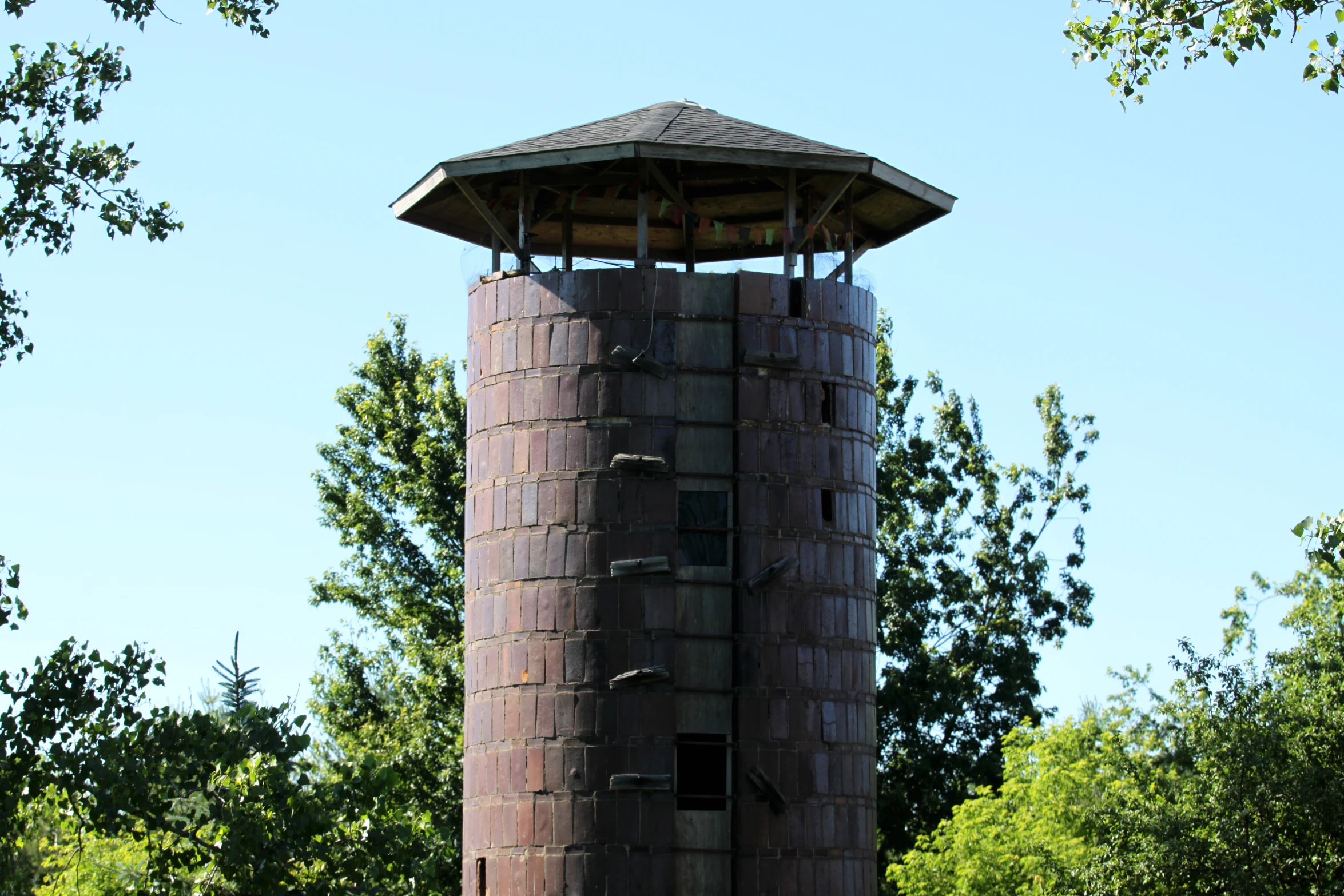 an unusual looking wooden tower with metal bars