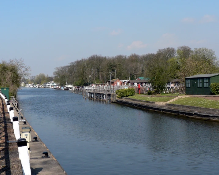 some long waterway with houses and a green building in the distance