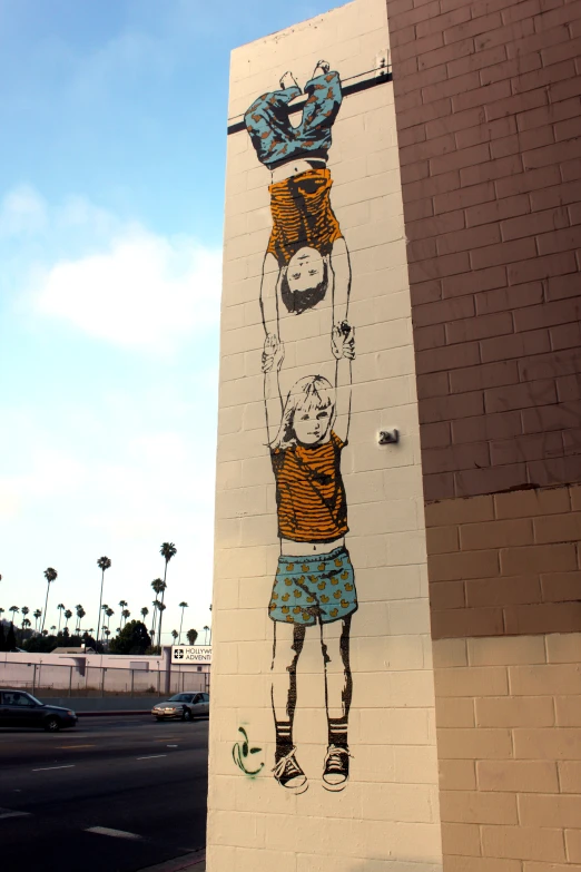 a painting on a cement wall shows a person carrying a child