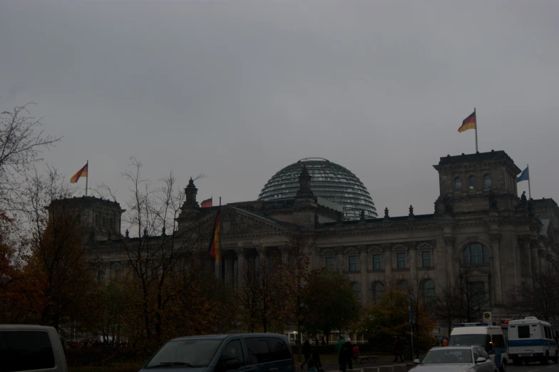 an old building with a dome and flags