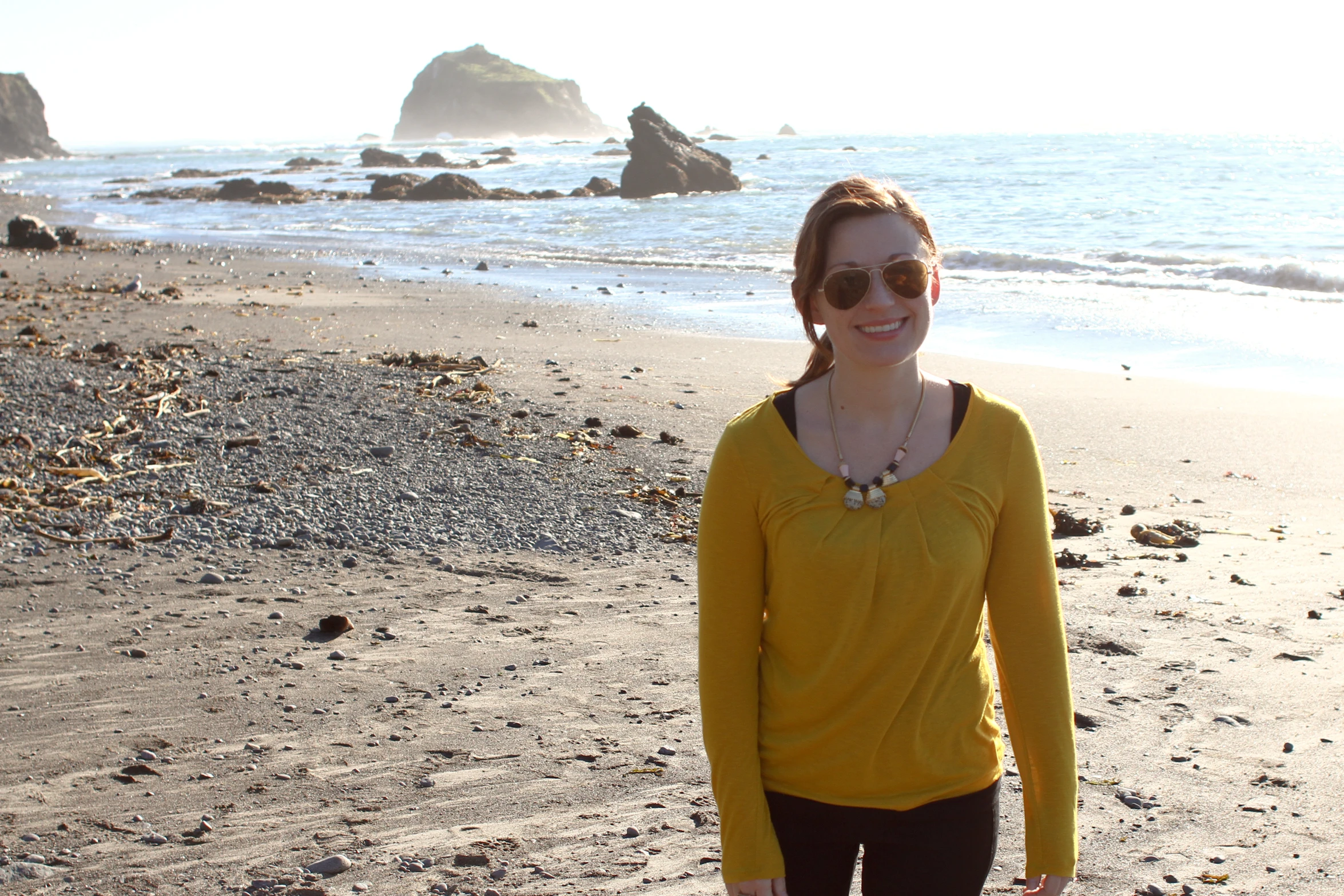 young lady in sunglasses standing on the beach