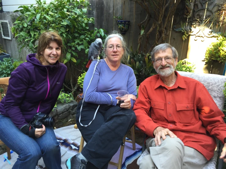 three people sitting down outside in the sun