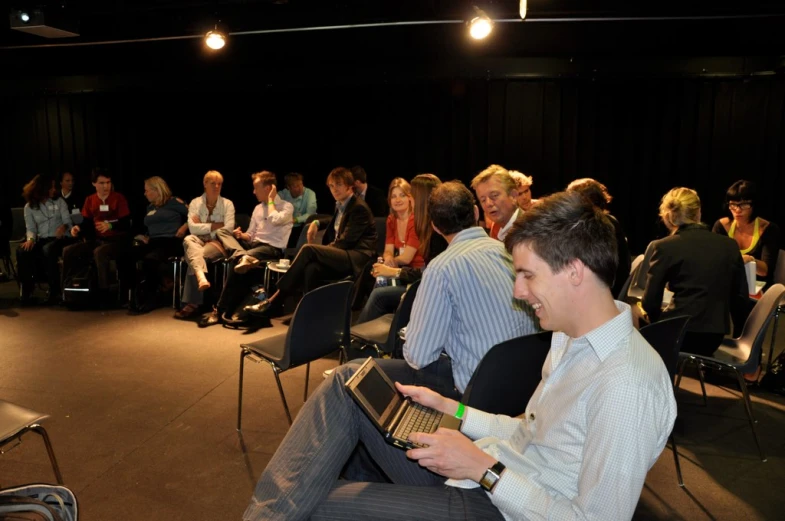 a man sitting down holding a laptop