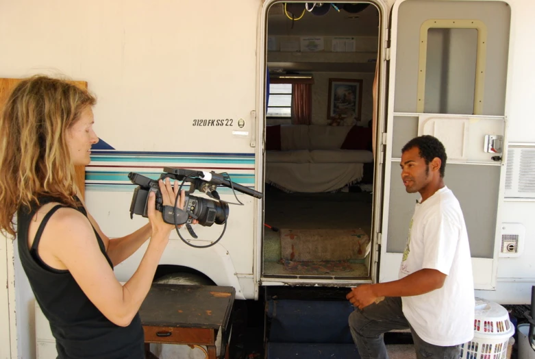 a man standing next to a woman in front of a white van