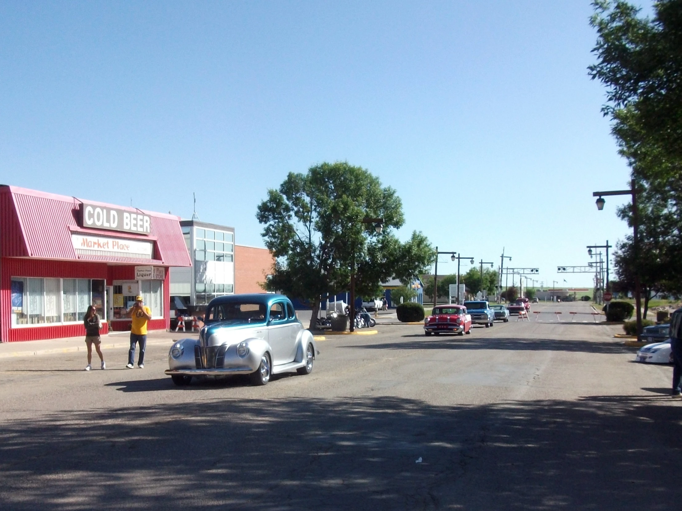 two people are standing next to an old car