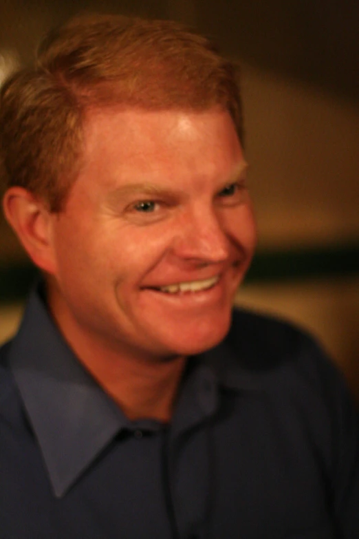 man smiles for camera while looking off into distance