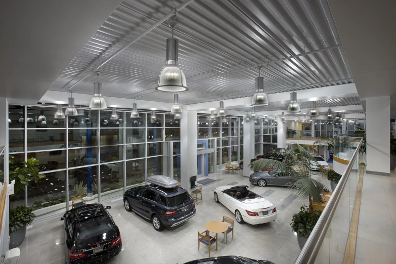 cars parked in a garage in front of glass doors
