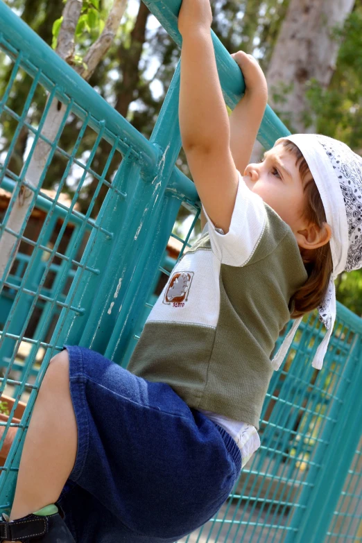 the toddler is playing in the fence with his toy