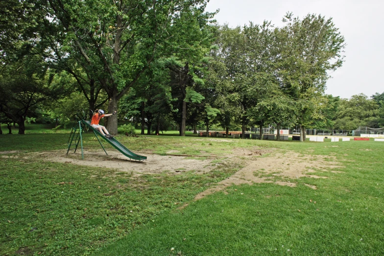 an empty playground in a park near some trees