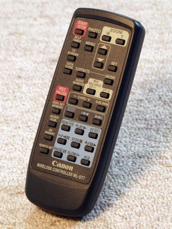 a black remote control is on the carpet