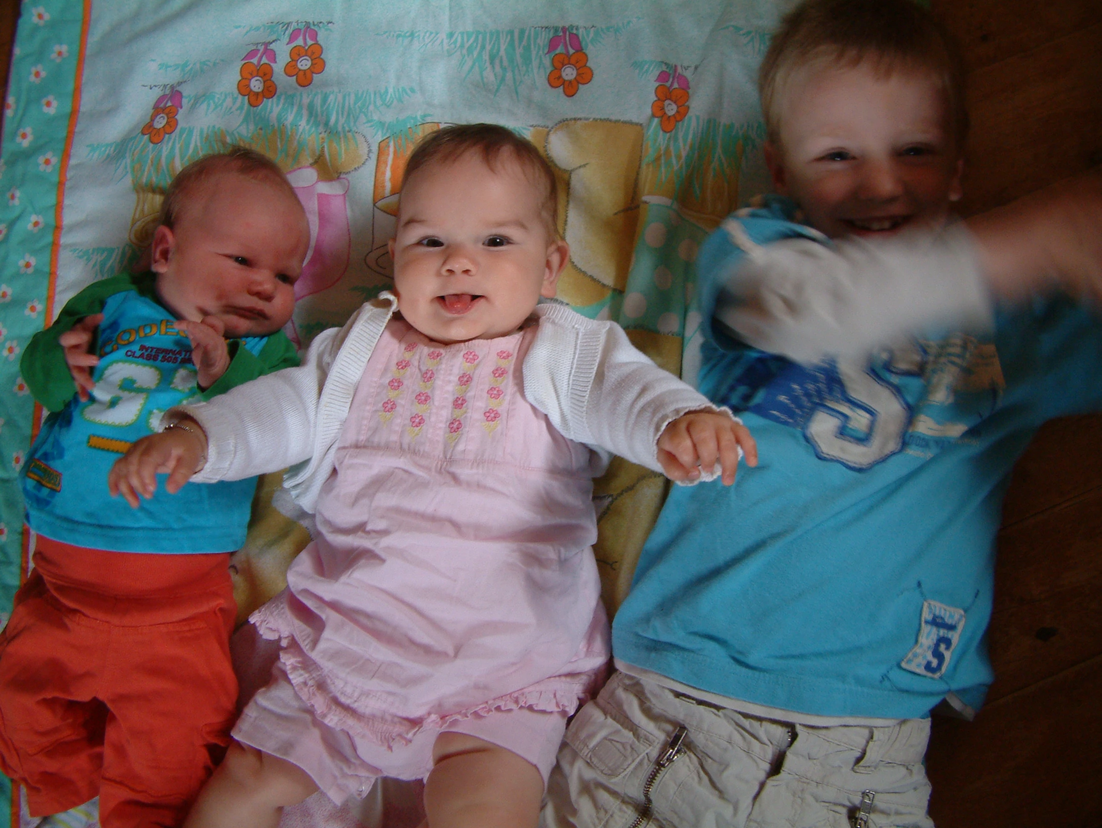 three young babies laying next to each other on a bed