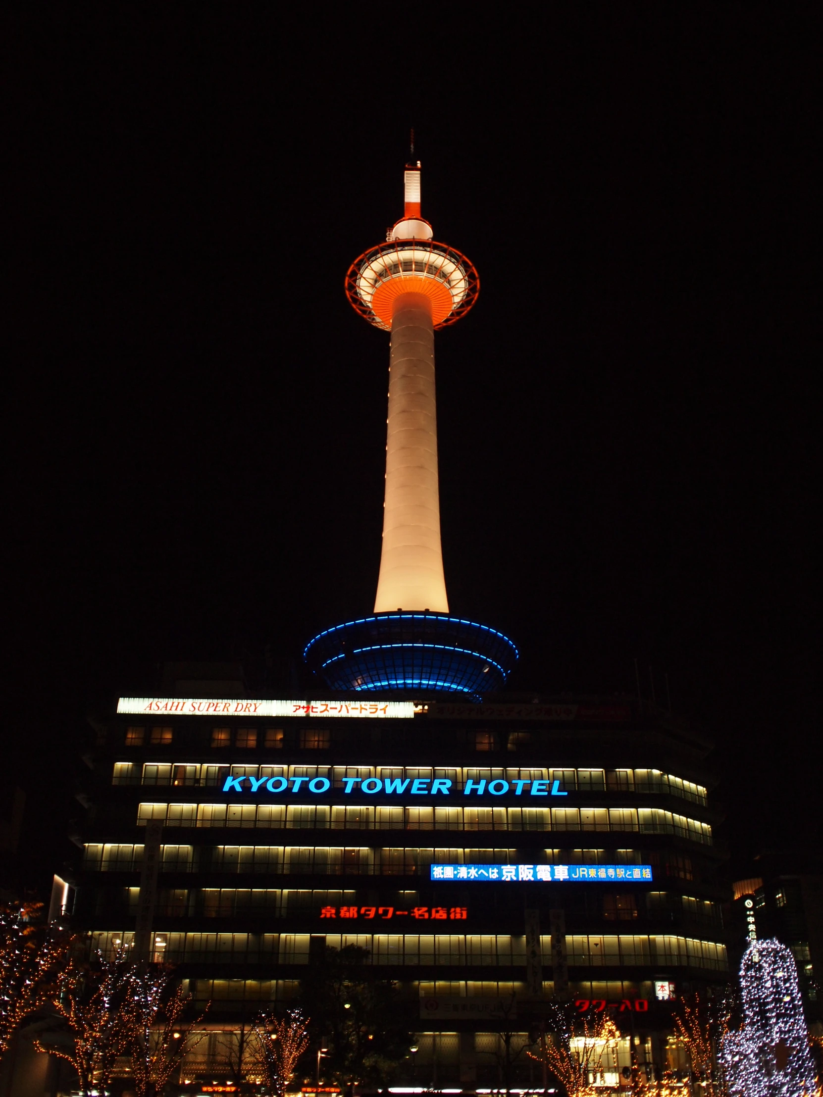 some lights and buildings with a building lit up in the night