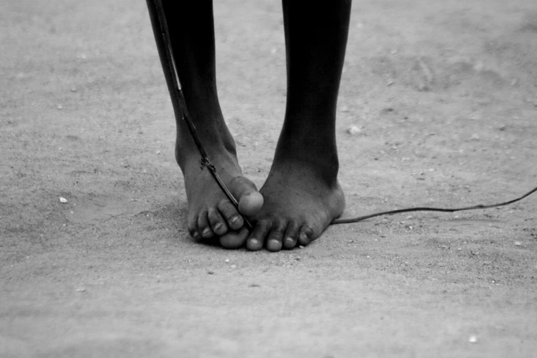 a person standing with their feet sticking out in the sand