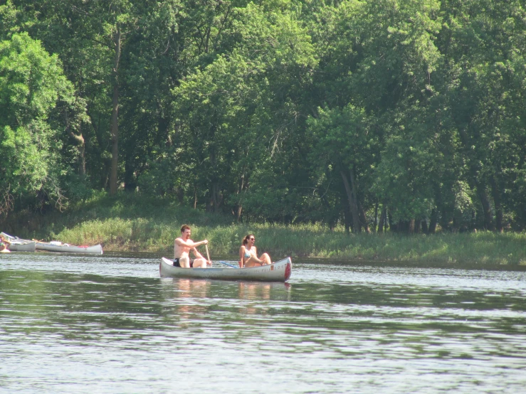 two people in a canoe paddling on a lake