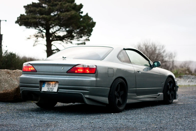 a sports car parked on gravel by the side of a building