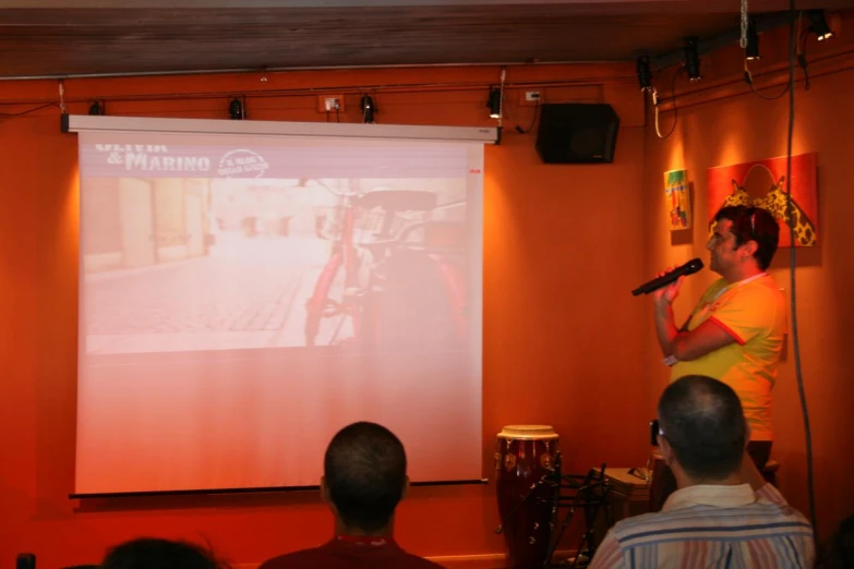 a man standing in front of a projected screen