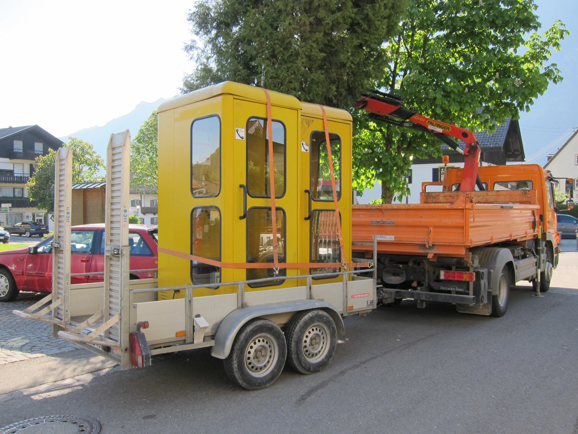 yellow truck towing a large orange cab on it's side