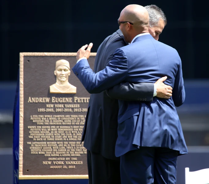 two men are at a memorial in front of a plaque