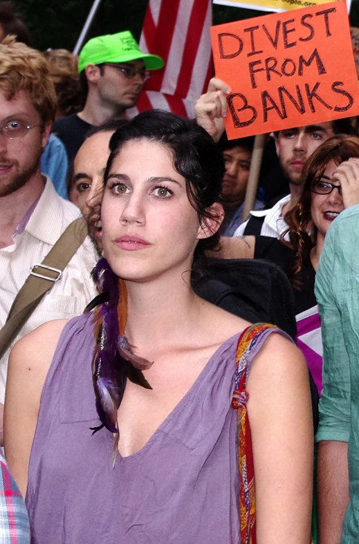 some people are taking pictures and one is holding a sign