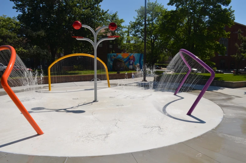 a little playground with the water sprinkles spraying all around it