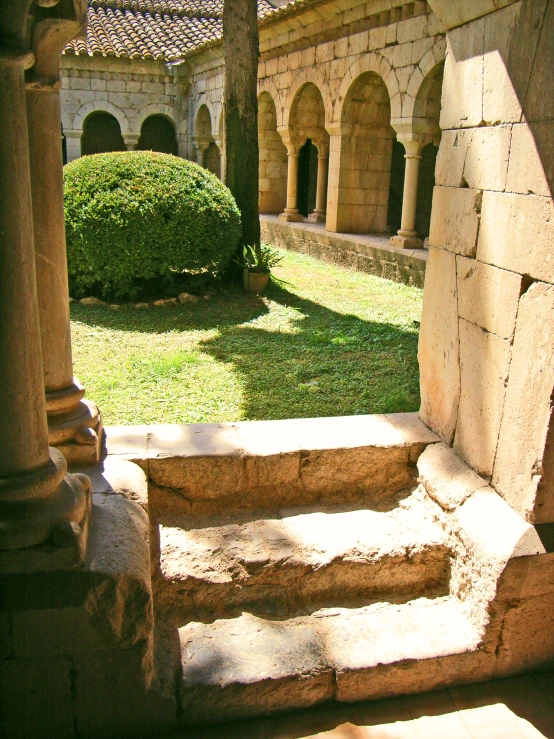 stairs lead down into an outdoor courtyard in front of an ancient stone wall