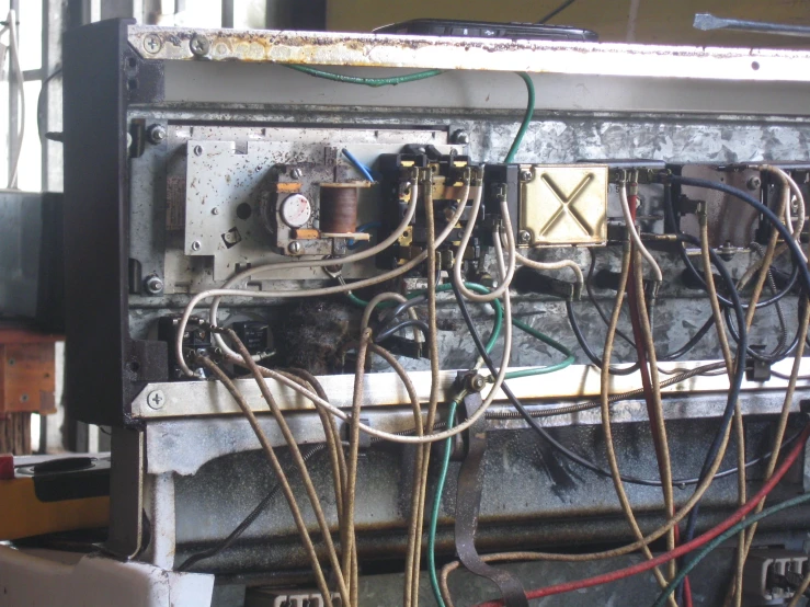electronic components in an old machine with wires hanging from the middle