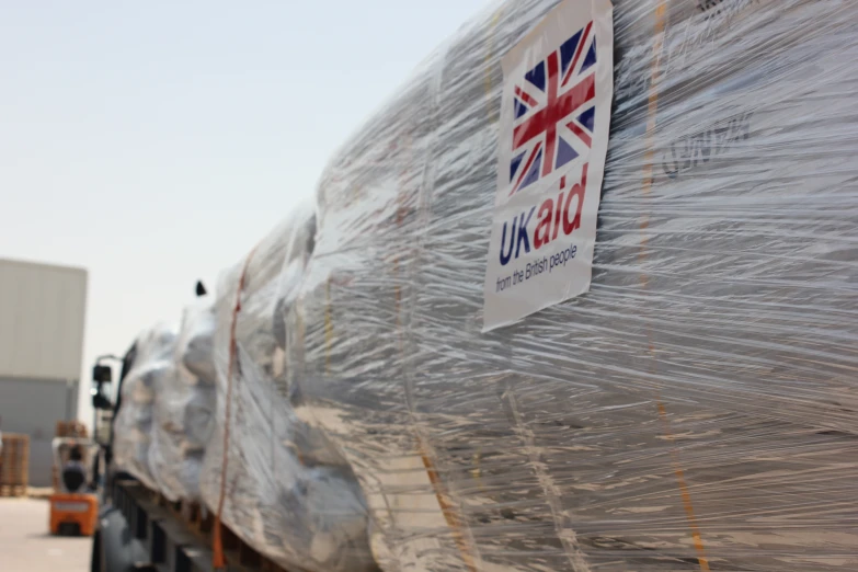 a truck is covered with plastic and there is the british flag on top