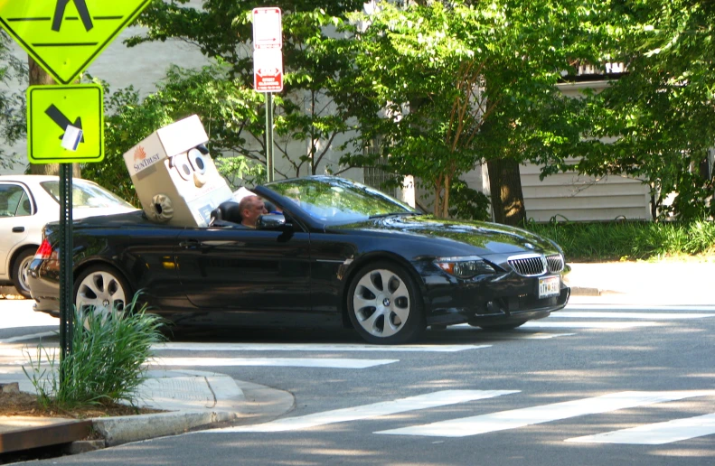 a man is sitting in the open top of a convertible