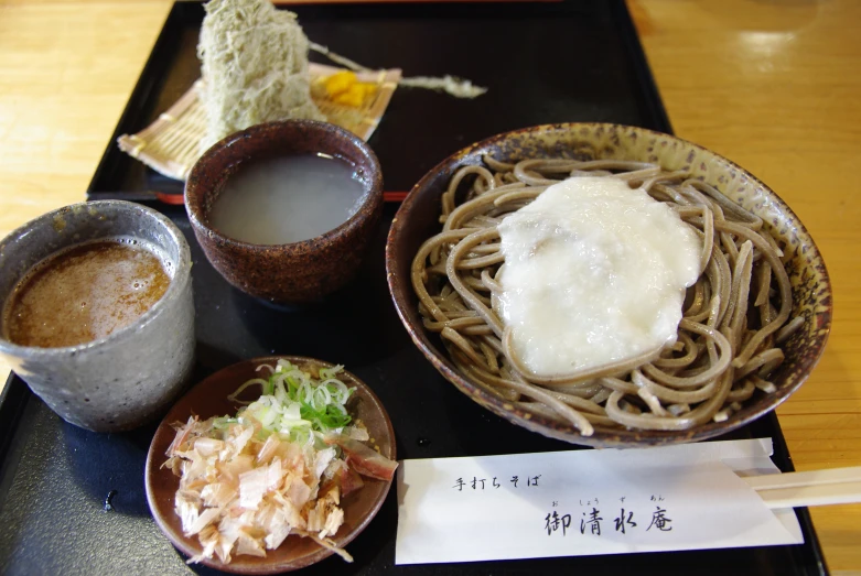 a wooden table topped with two bowls filled with different types of food