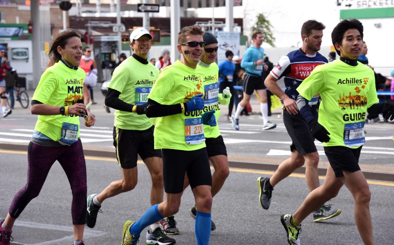 people in colorful shirts run together in a street